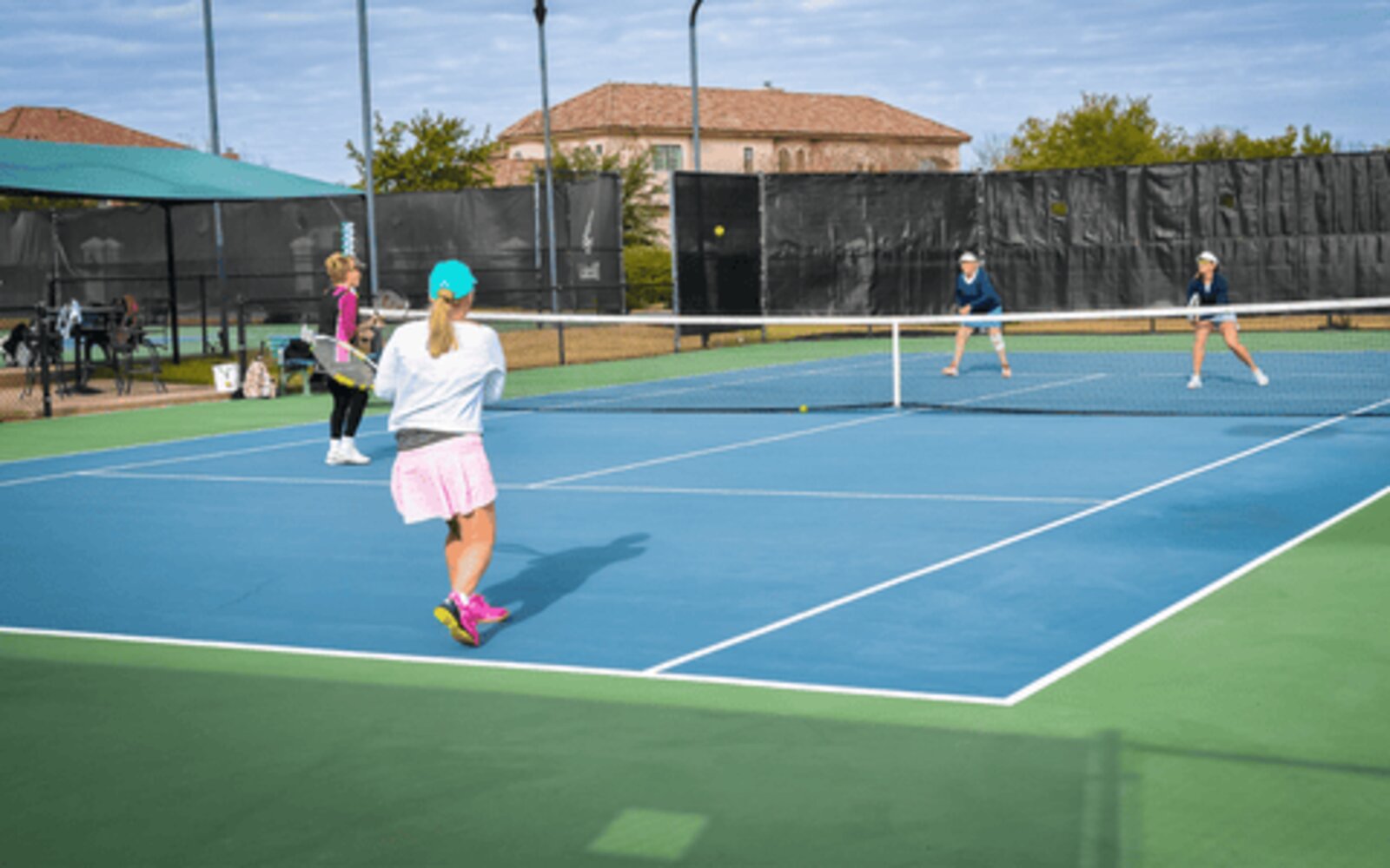 Two women playing doubles on a hard court